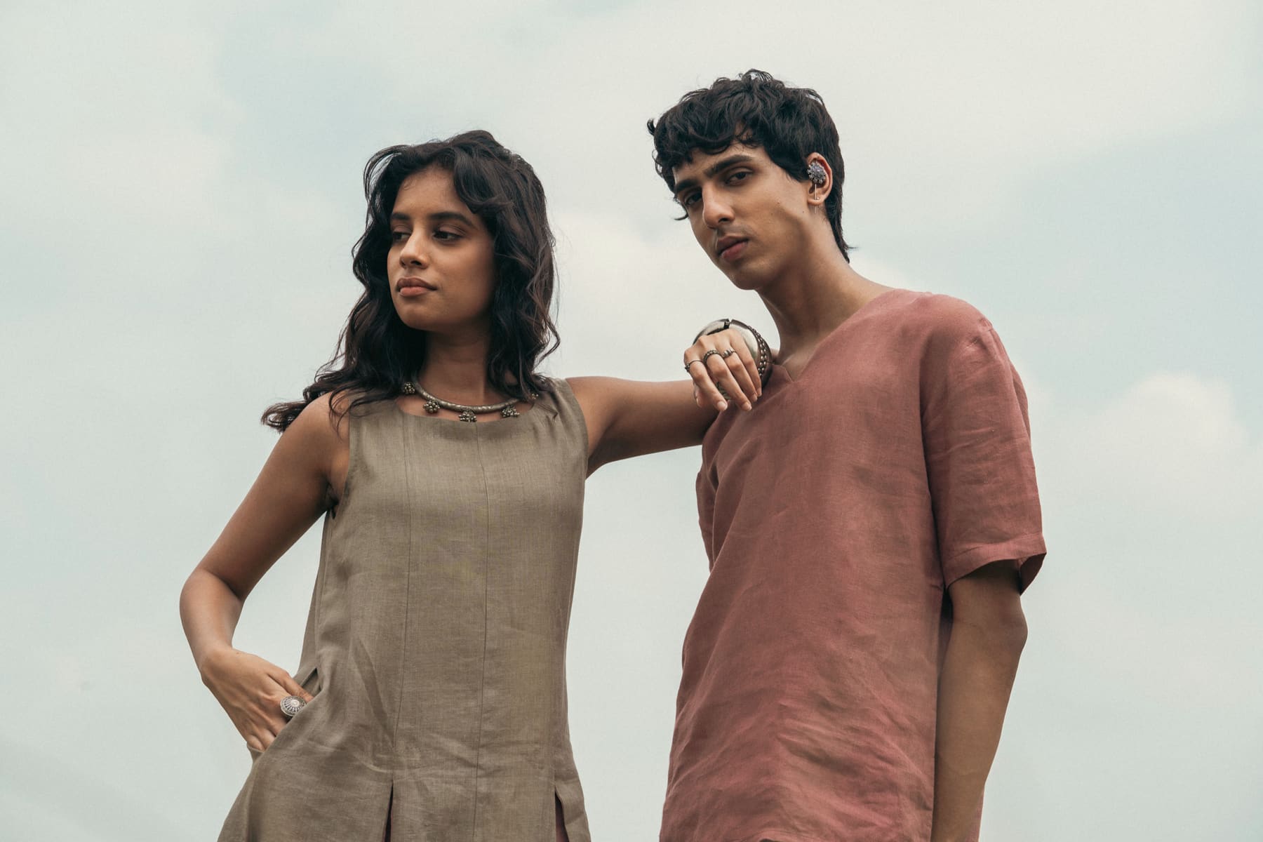Two models wearing Reshakaar by Rosh linen pieces against a pale sky